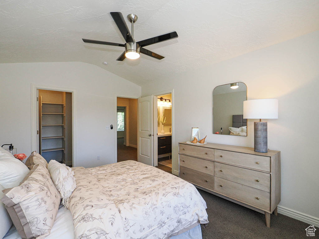 Bedroom with lofted ceiling, a spacious closet, ceiling fan, and ensuite bathroom