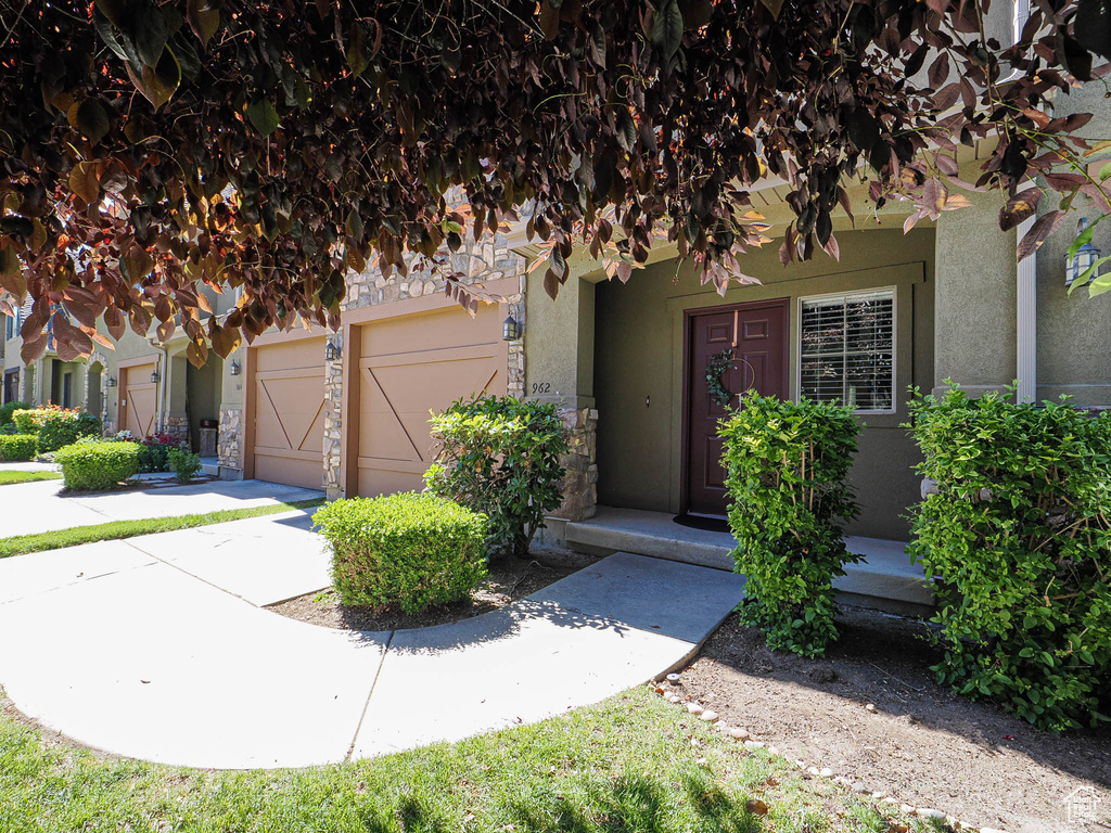 View of front of home with an attached garage and stucco siding