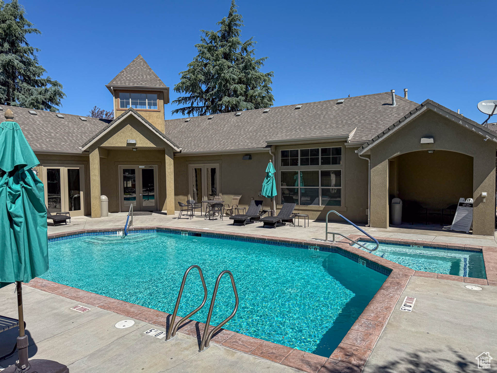 Community pool with french doors and a patio