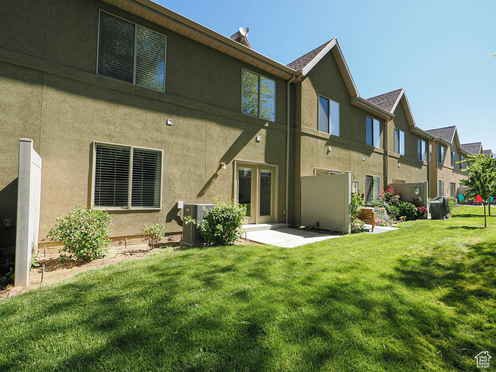Back of property with a yard, stucco siding, and a residential view