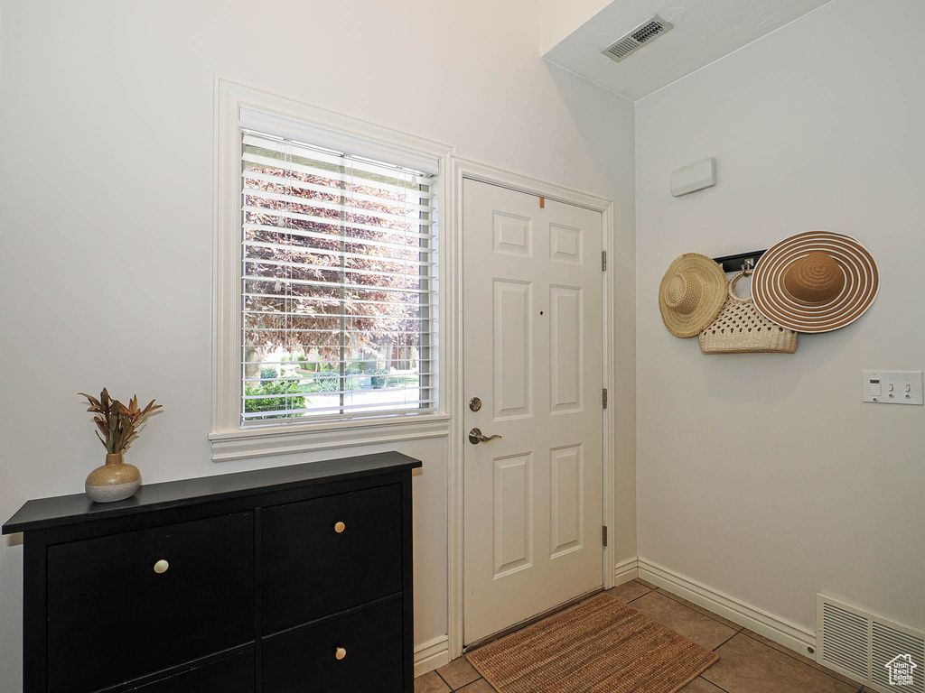 Entrance foyer featuring light tile patterned floors and baseboards