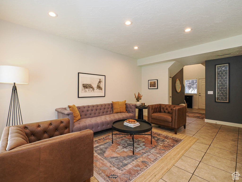 Living room with light tile patterned flooring and recessed lighting