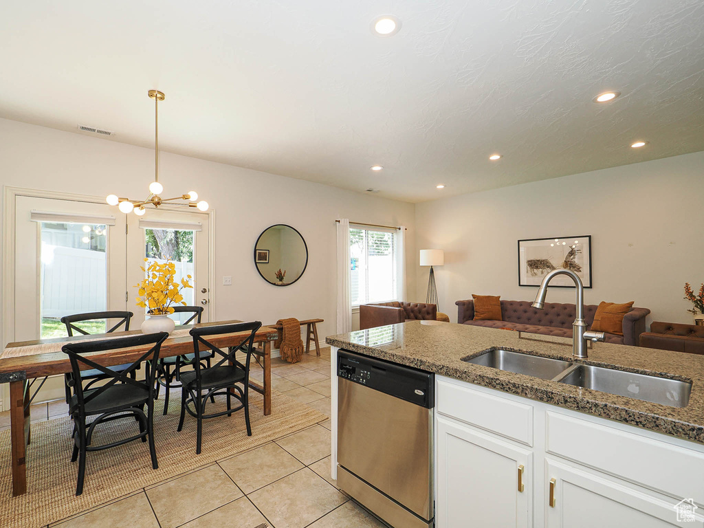 Kitchen featuring stainless steel dishwasher, light tile patterned flooring, white cabinetry, dark stone countertops, and recessed lighting
