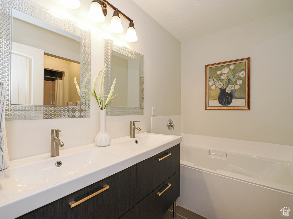 Full bath featuring double vanity and a bath