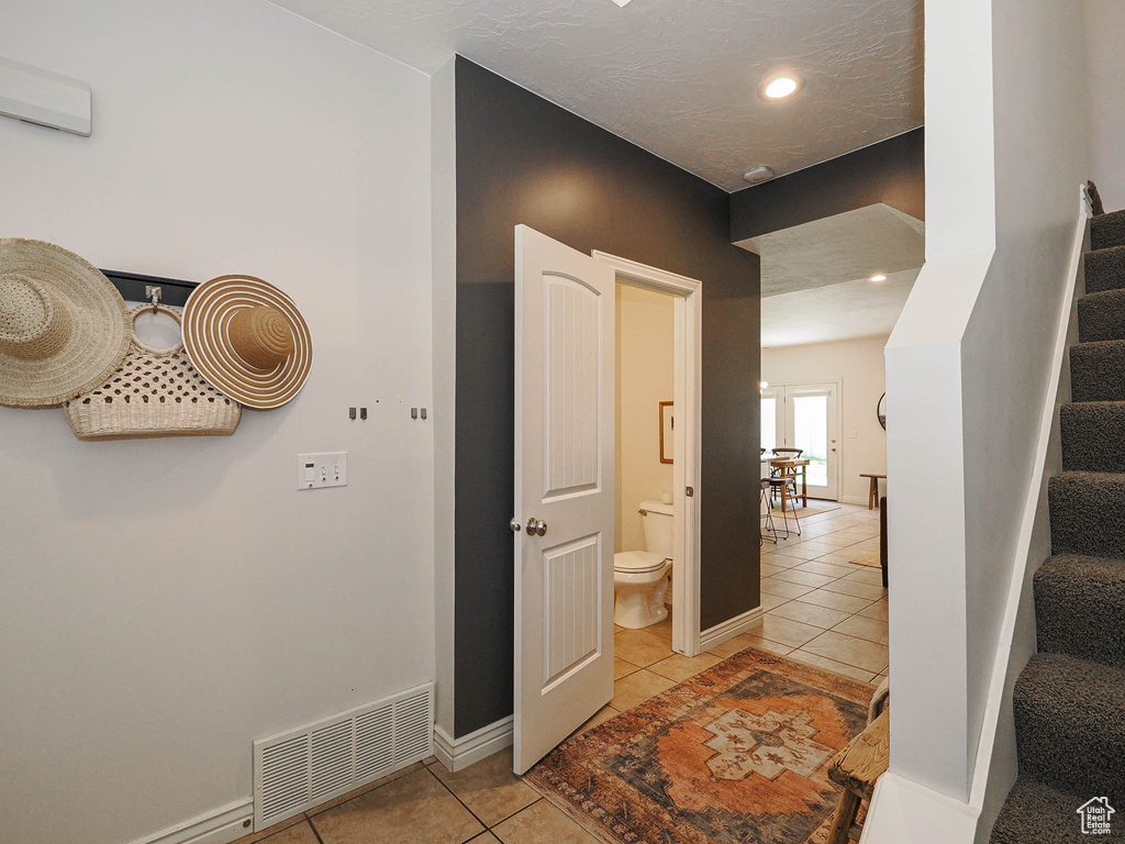 Hallway featuring light tile patterned floors, stairway, and recessed lighting