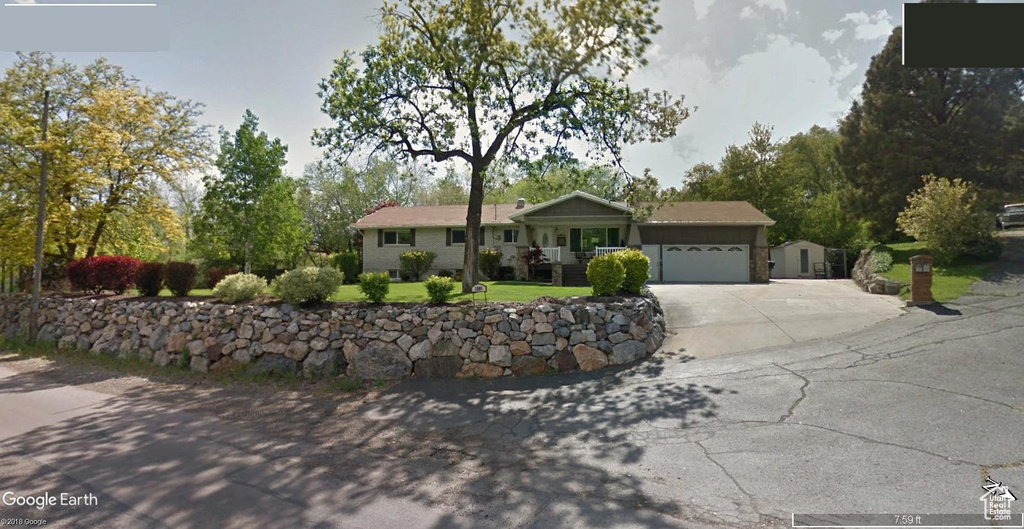 Single story home with driveway and a garage