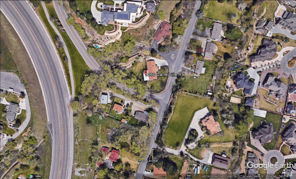 Aerial view of property and surrounding area featuring nearby suburban area