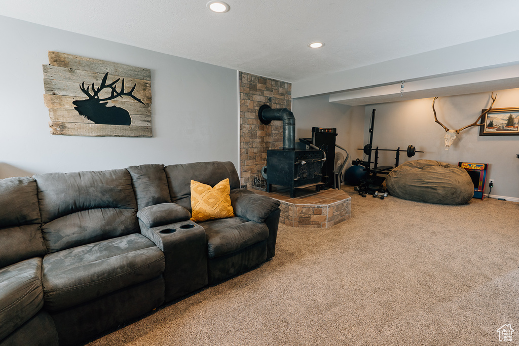Living area with a wood stove, carpet floors, and recessed lighting