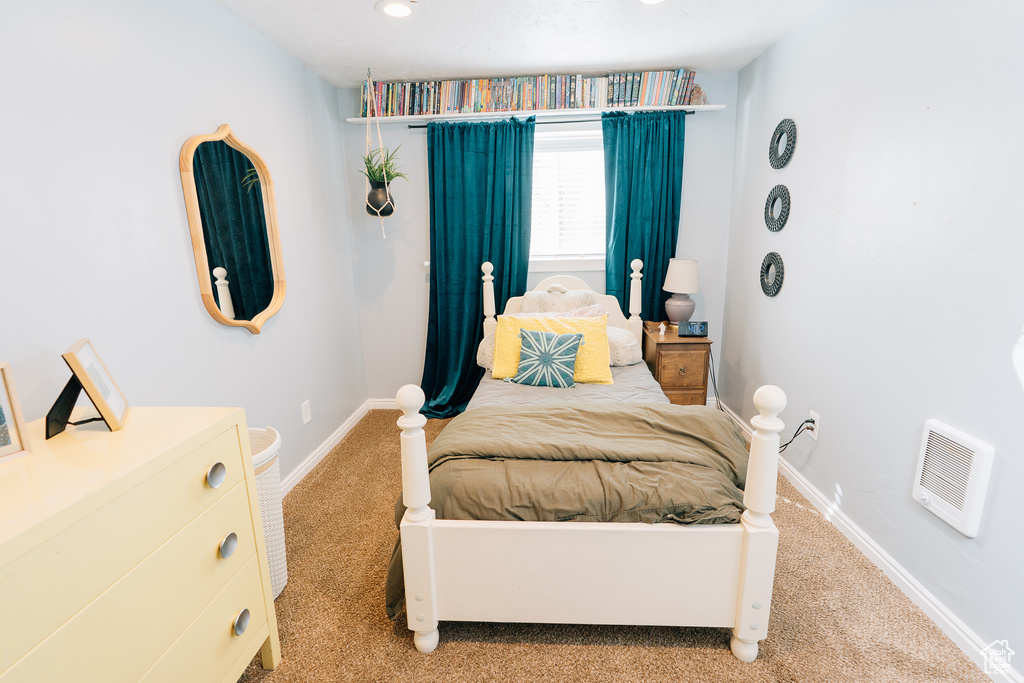Carpeted bedroom with baseboards and heating unit