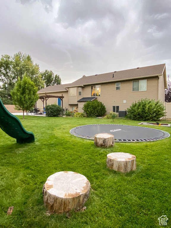 Back of property with a playground, a lawn, and a gazebo