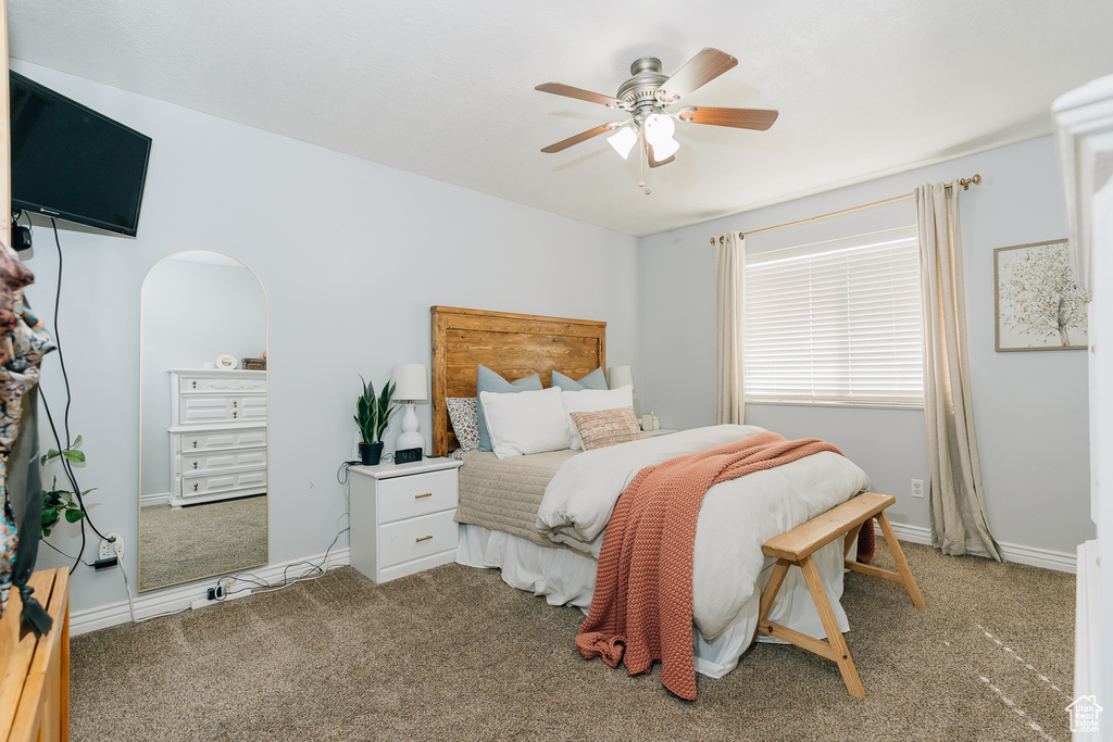Bedroom with carpet, arched walkways, and ceiling fan