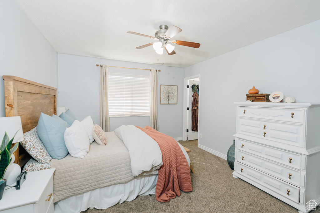 Bedroom with light colored carpet and a ceiling fan