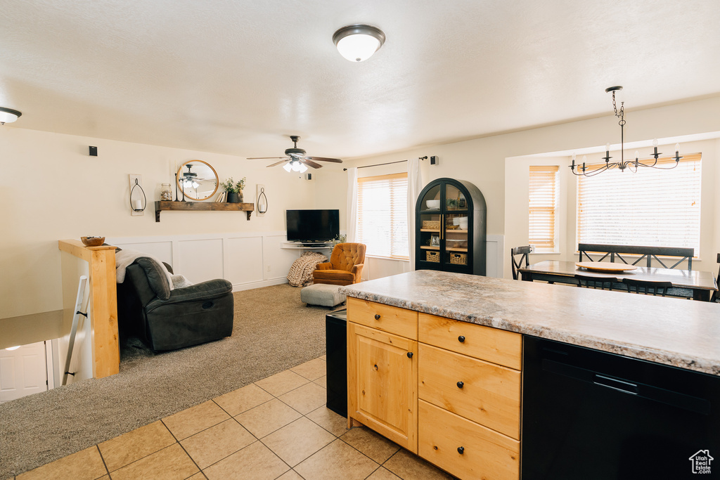 Kitchen featuring dishwashing machine, light colored carpet, light countertops, and a ceiling fan