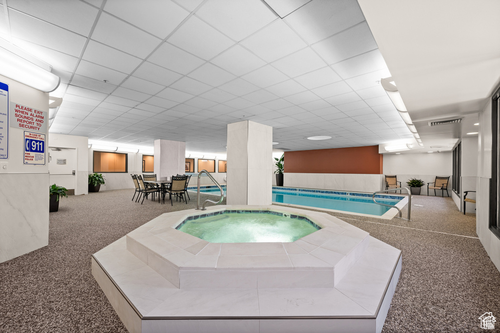 View of swimming pool with a hot tub