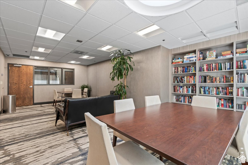 Carpeted dining room with a paneled ceiling