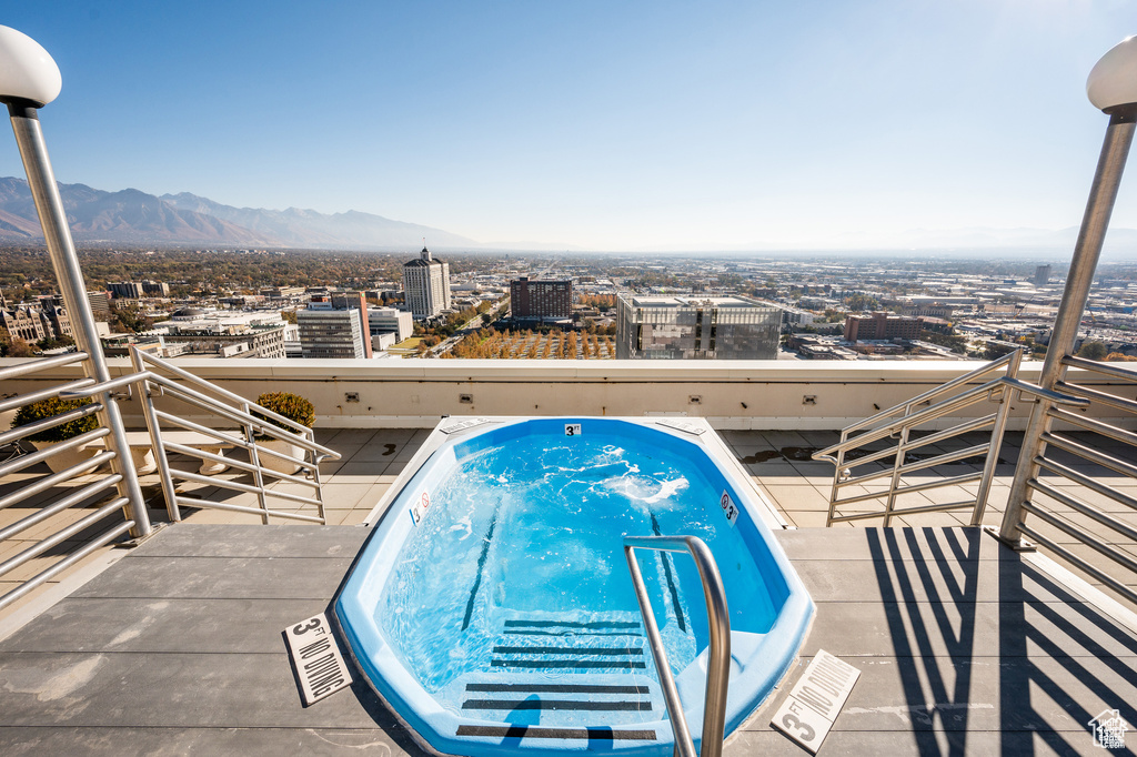 View of pool with a jacuzzi, a view of city, and a mountain view