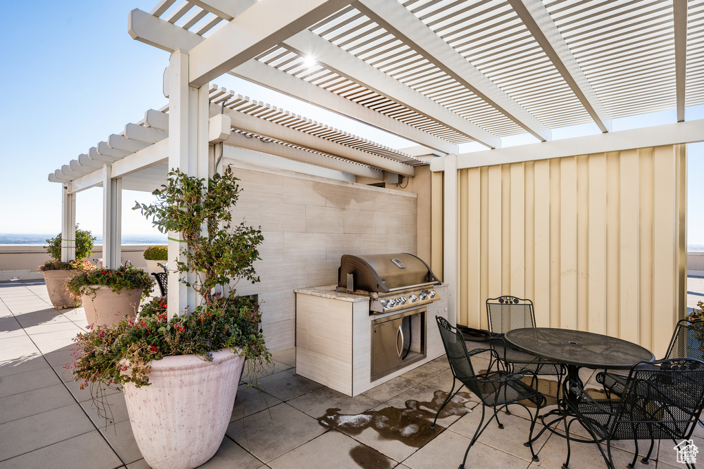 View of patio / terrace with area for grilling, a pergola, and outdoor dining space