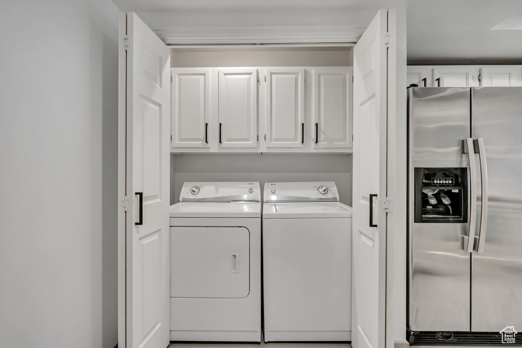 Laundry room with washer and clothes dryer and cabinet space