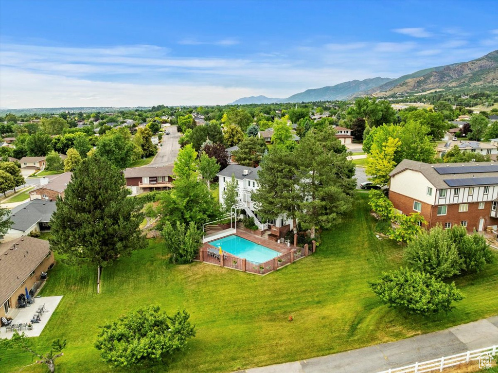 Aerial view of residential area featuring a pool area and a mountainous background