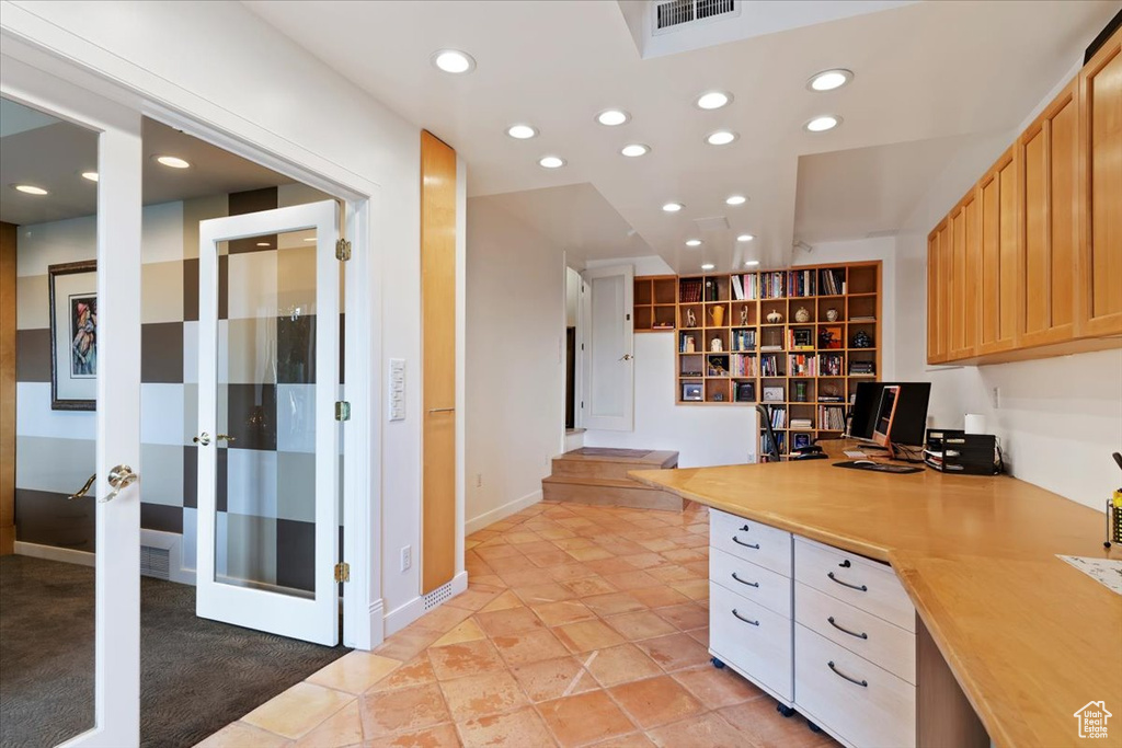 Unfurnished office featuring recessed lighting, built in desk, and french doors