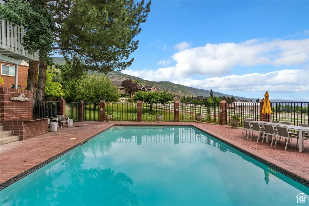 View of pool with a mountain view and a patio area