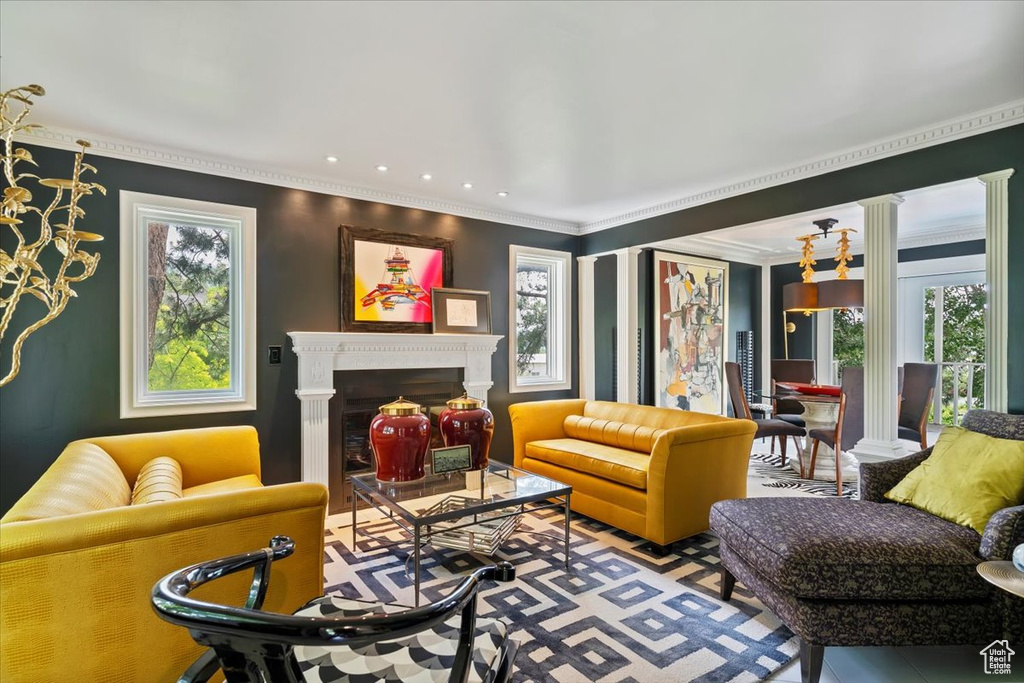 Living area featuring plenty of natural light, a fireplace, and crown molding