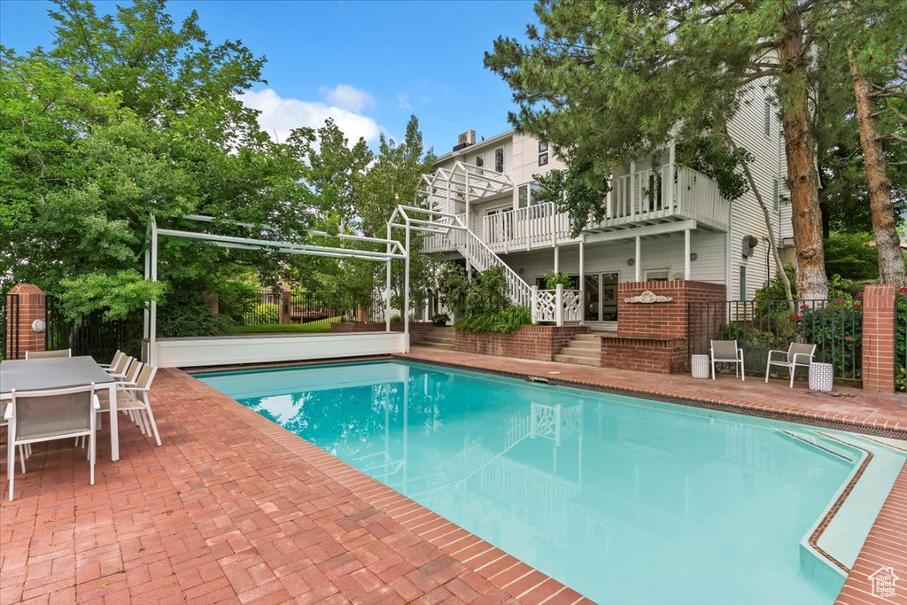 Outdoor pool featuring stairs, a patio, and outdoor dining space