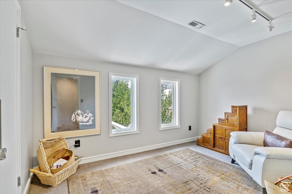 Sitting room with rail lighting, lofted ceiling, carpet floors, and stairs