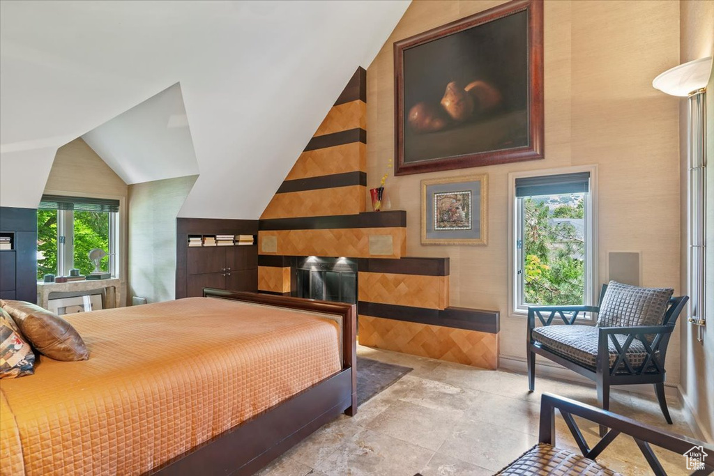 Bedroom featuring stone finish flooring and vaulted ceiling