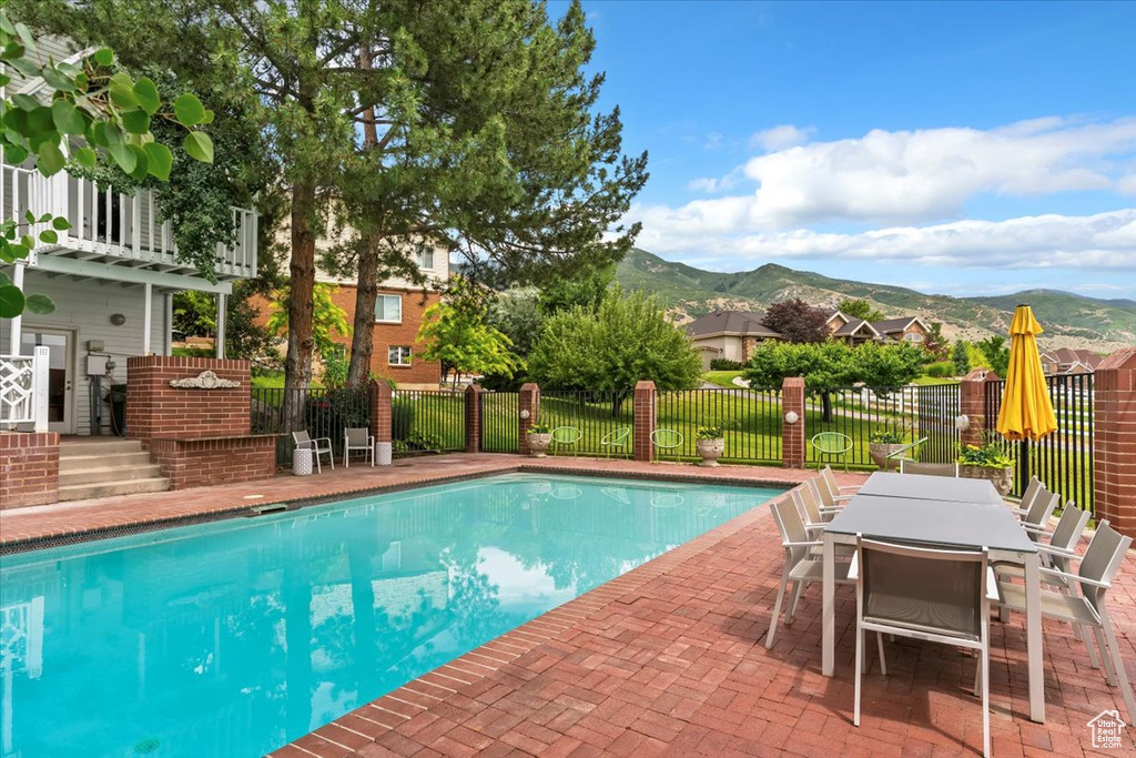 View of pool with a mountain view, a patio area, and outdoor dining area