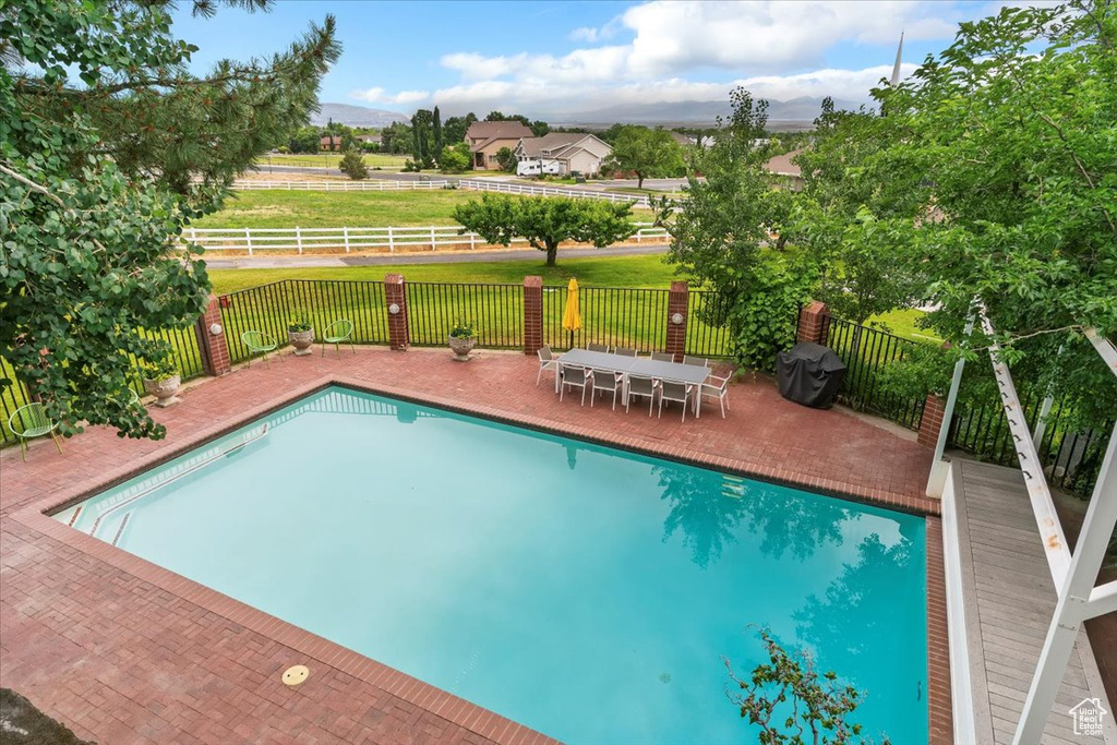 View of swimming pool with a patio area and a mountain view