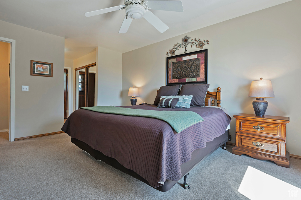 Carpeted bedroom with a closet and a ceiling fan