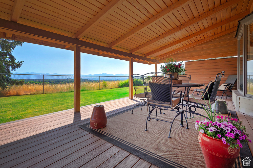 Wooden deck featuring outdoor dining space and a mountain view