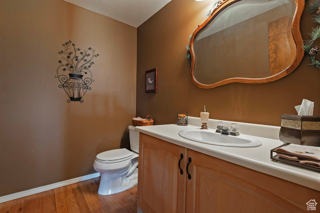 Half bathroom with vanity and wood finished floors