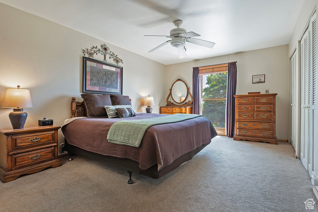 Carpeted bedroom featuring a closet and a ceiling fan