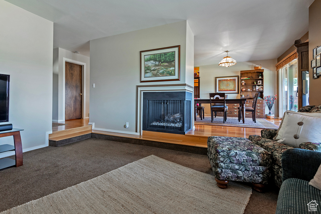 Living room featuring carpet, a chandelier, and a fireplace