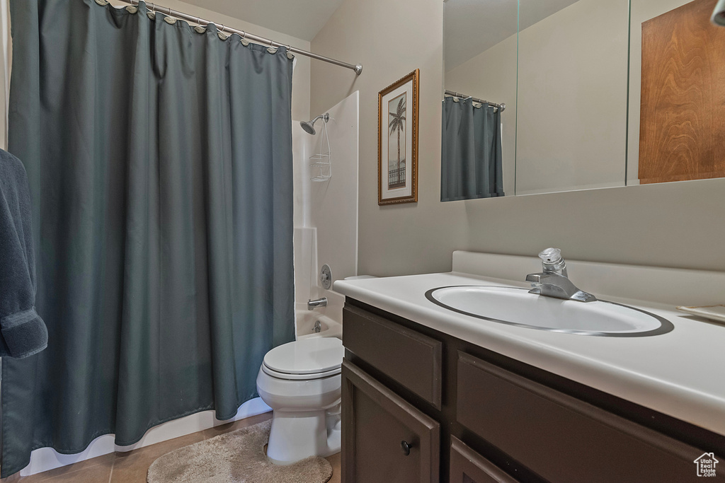 Full bathroom with vanity, shower / tub combo, and tile patterned floors