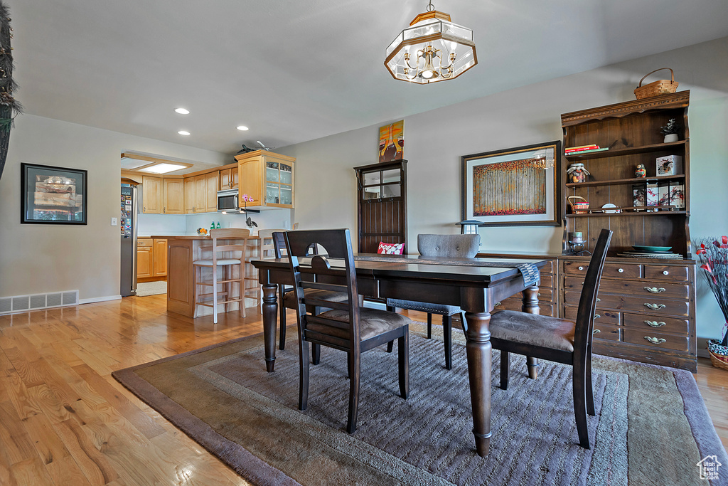 Dining room featuring light wood-style flooring, recessed lighting, and a chandelier