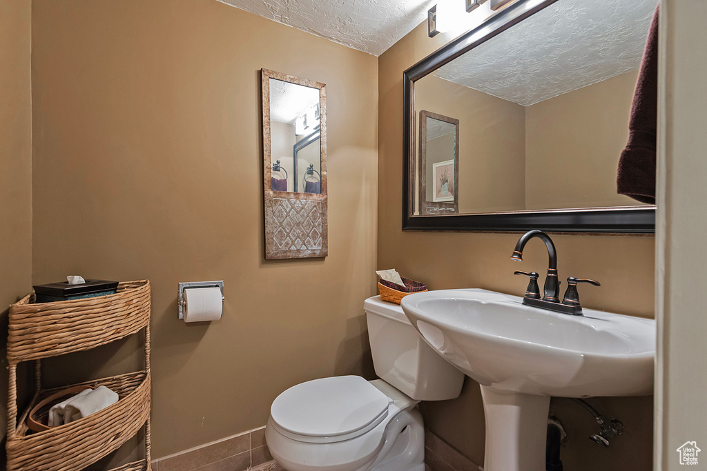 Bathroom with a textured ceiling and tile patterned floors