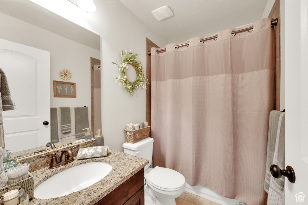 Full bath with vanity and tile patterned flooring