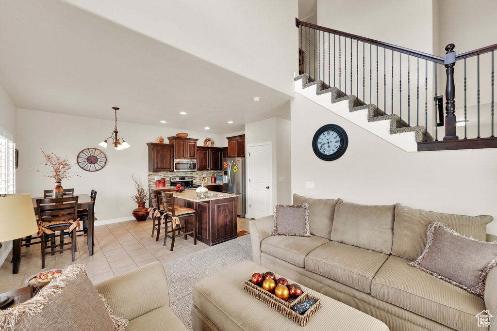 Living room with light tile patterned flooring, a chandelier, and recessed lighting