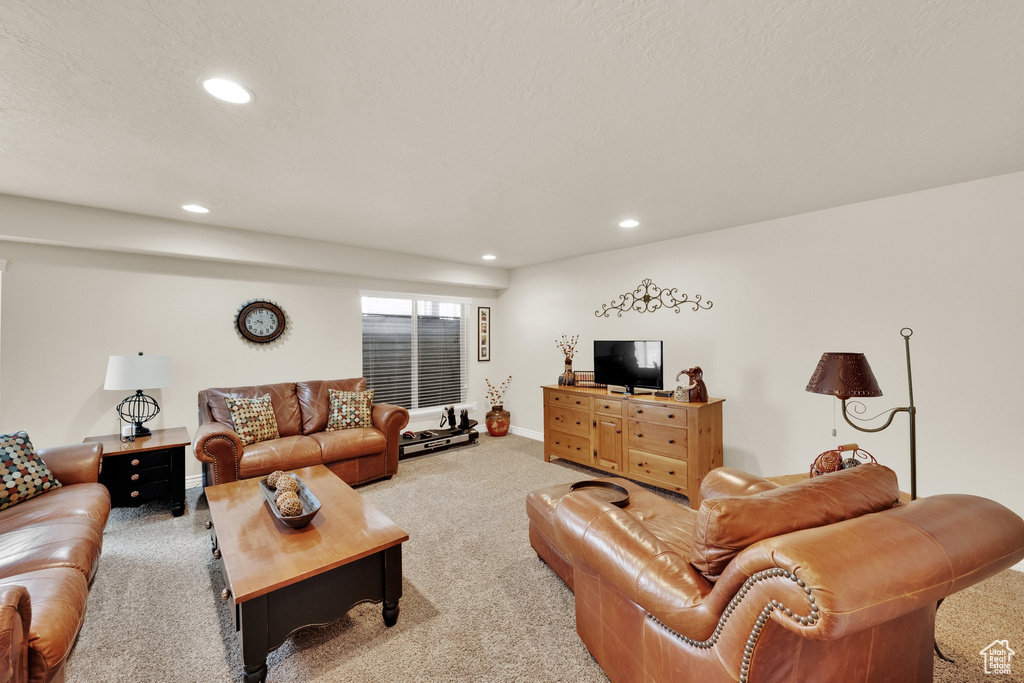 Carpeted living area with recessed lighting