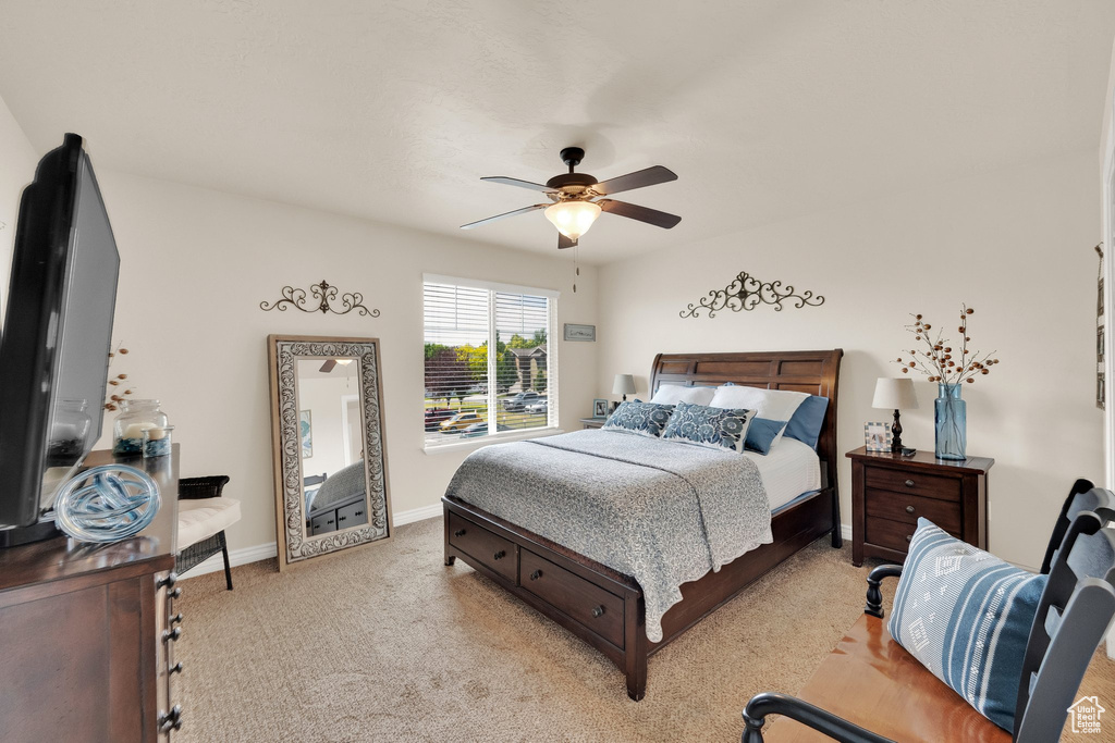 Bedroom with light carpet and a ceiling fan