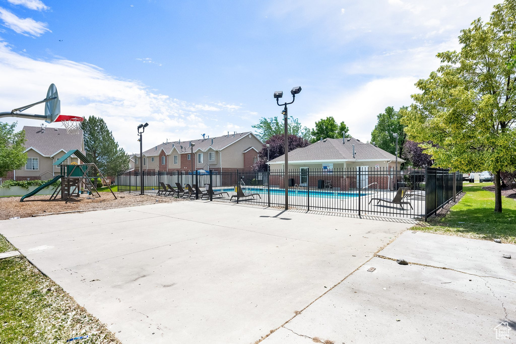 View of sport court with a community pool and a residential view