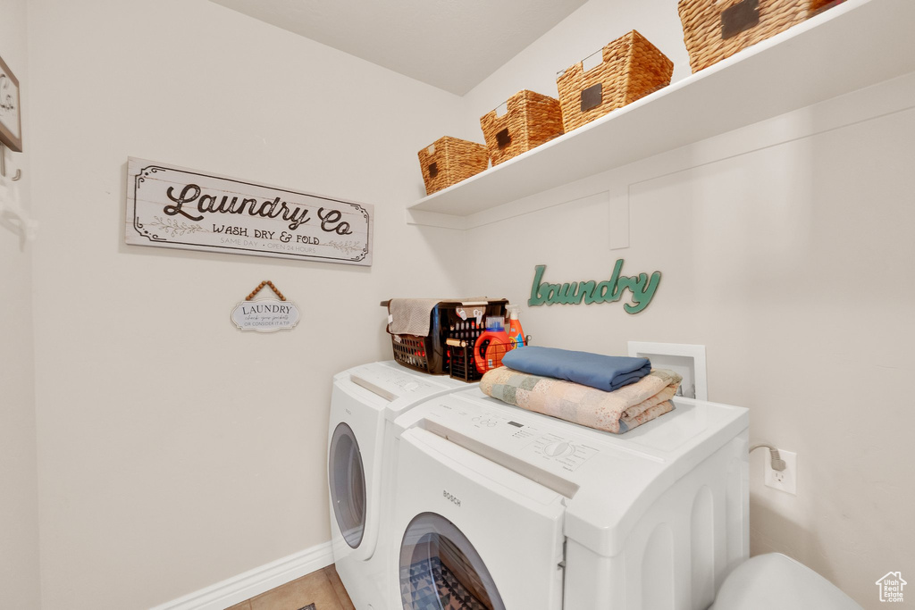 Laundry room featuring washing machine and clothes dryer and baseboards