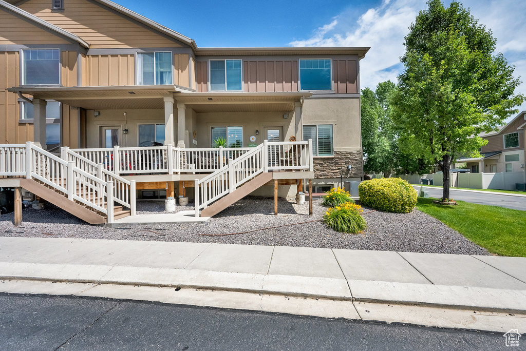 View of front of home featuring a porch, board and batten siding, stairs, and stucco siding