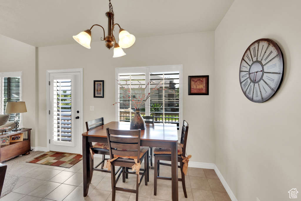 Dining area with light tile patterned floors and a chandelier