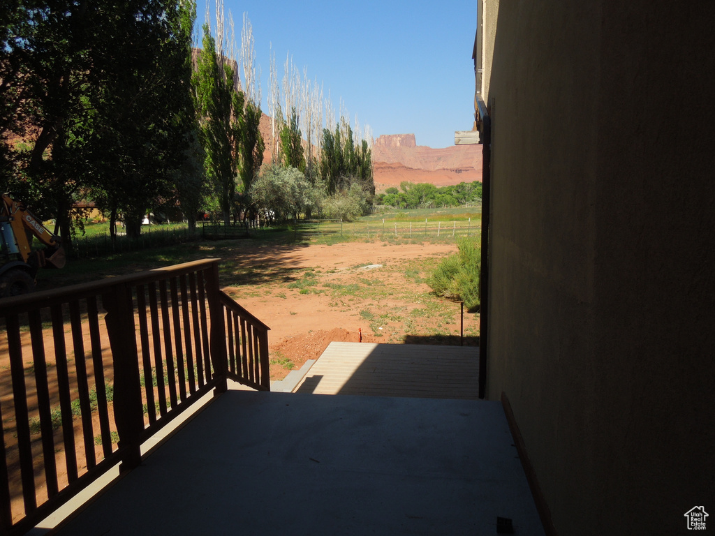 Wooden deck featuring a mountain view, a rural view, and a patio