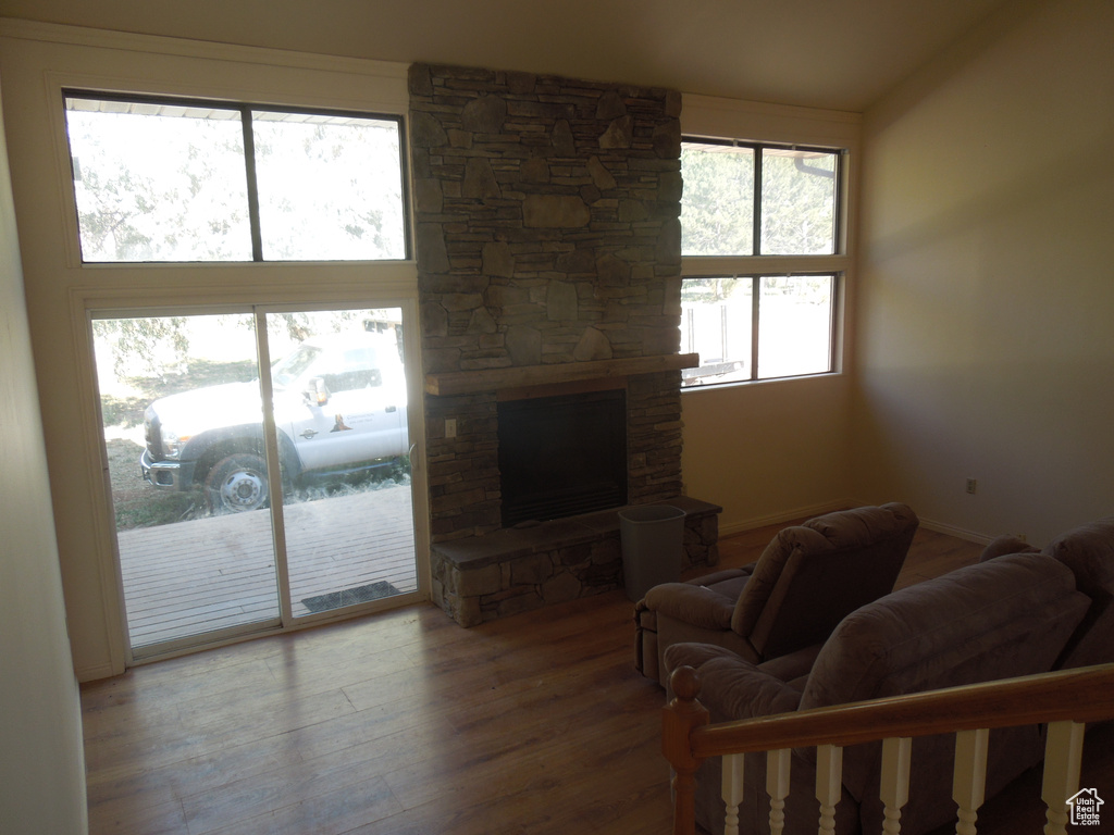 Living room with wood finished floors and a stone fireplace