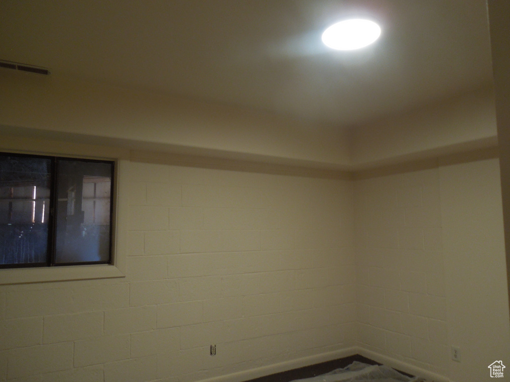 Unfurnished room featuring concrete block wall